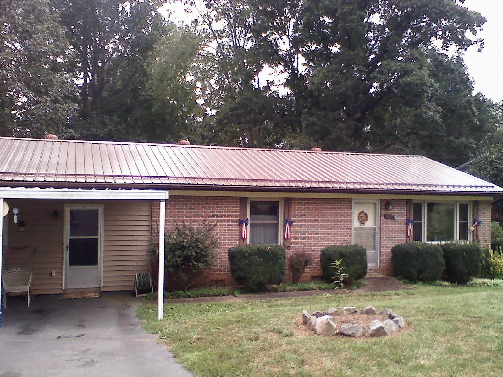 Bronze metal roof and carport on a brick ranch home — Roof Repair work by our crew in Millwood
